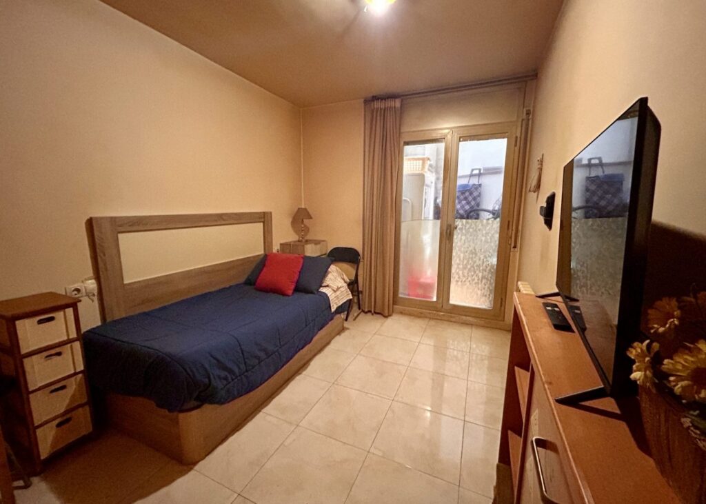 Dormitorio con cama y balcón
