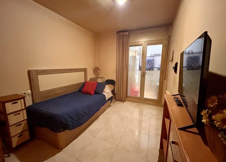 Dormitorio con cama y balcón, piso de 2 habitaciones en venta en Girona
