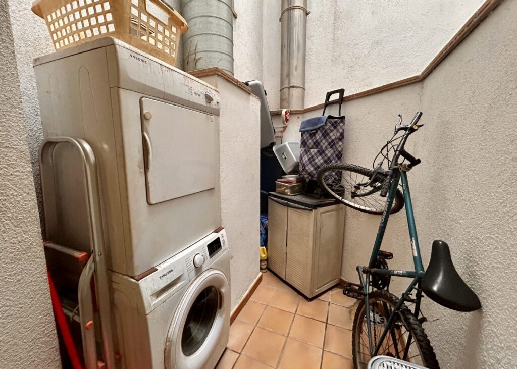 Trastero con lavadora-secadora y bicicleta