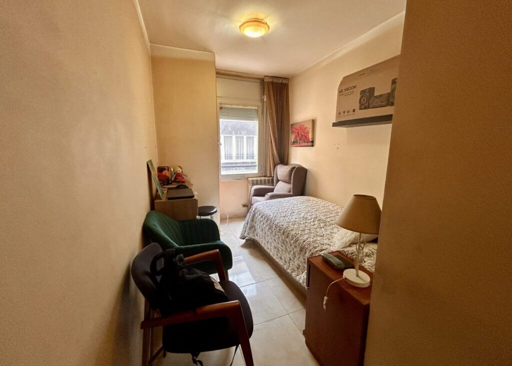 Dormitorio con sillón y cabecero